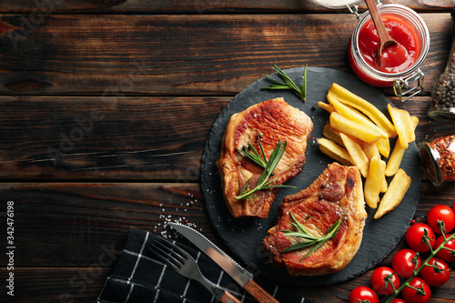 Composition with fried steaks on wooden background. Grilled food