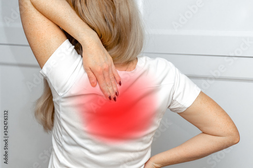 A woman in white dress feeling pain on his back. Office syndrome. Back pain from work. Herniated nucleus pulposus. spine pain. spinal degeneration. photo