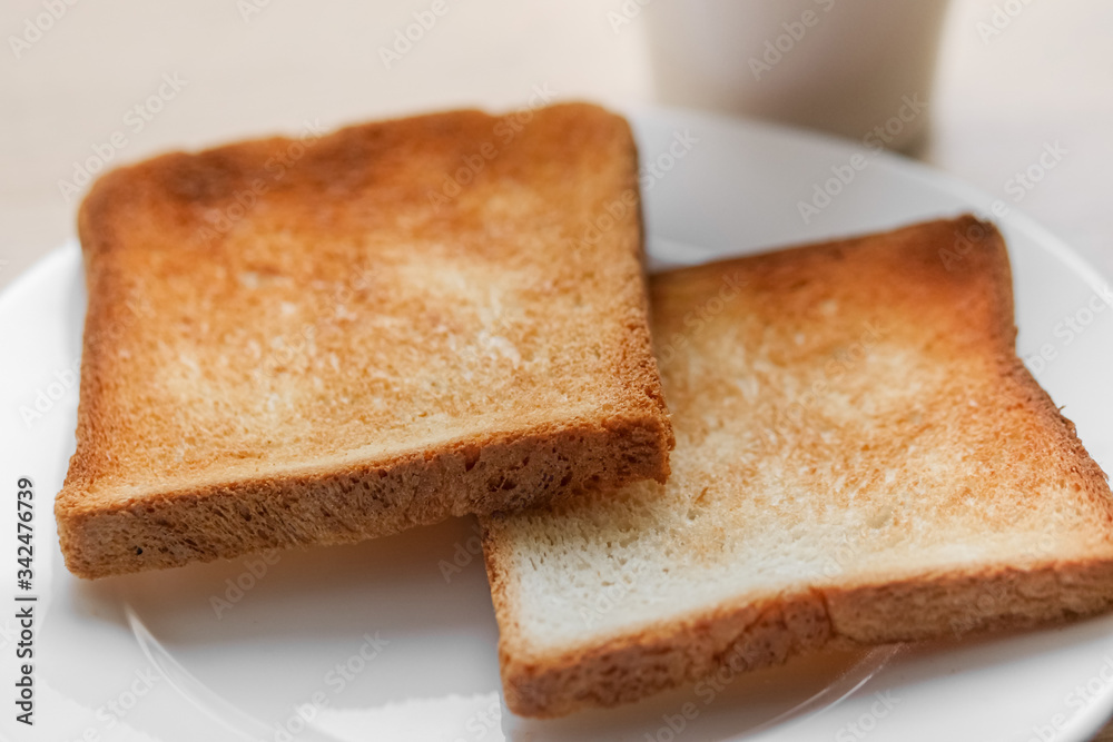 freshly baked toaster bread. Tasty toasted bread on wooden board. A couple of crusty toasts in the toaster, close-up. delicious breakfast