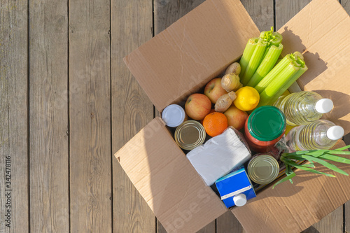 A box with products stands on a wooden floor. Quarantine home delivery concept.