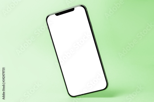 Smartphone mockup, phone with blank screen and shadow isolated on green background. Symbol of lightness freshness airiness. Copy space, modern technologies social networks and applications.