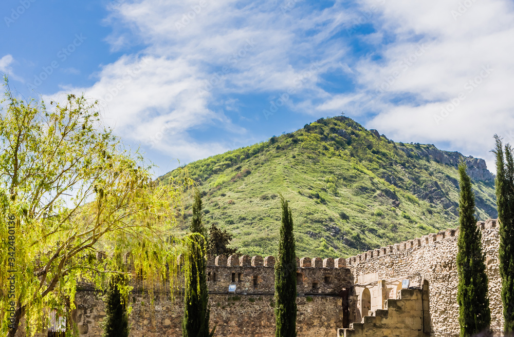 Panoramic view of the Caucasus mountains, with the Svetitskhoveli Cathedral external wall in the foreground. Located in Mtskheta village, near Tbilisi, Georgia...Y