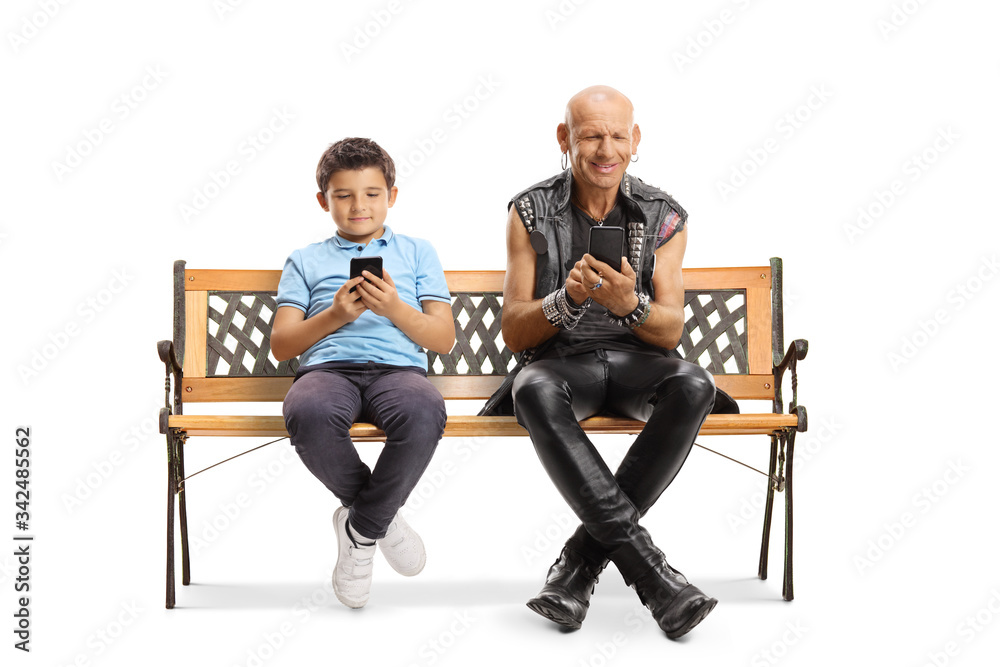 Boy and a punk sitting on a bench and typing on mobile phones Boy and a punk sitting on a bench and typing on mobile phones