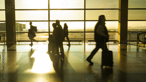 SILHOUETTE: Travelers hurry down airport hall as they try to reach their gate