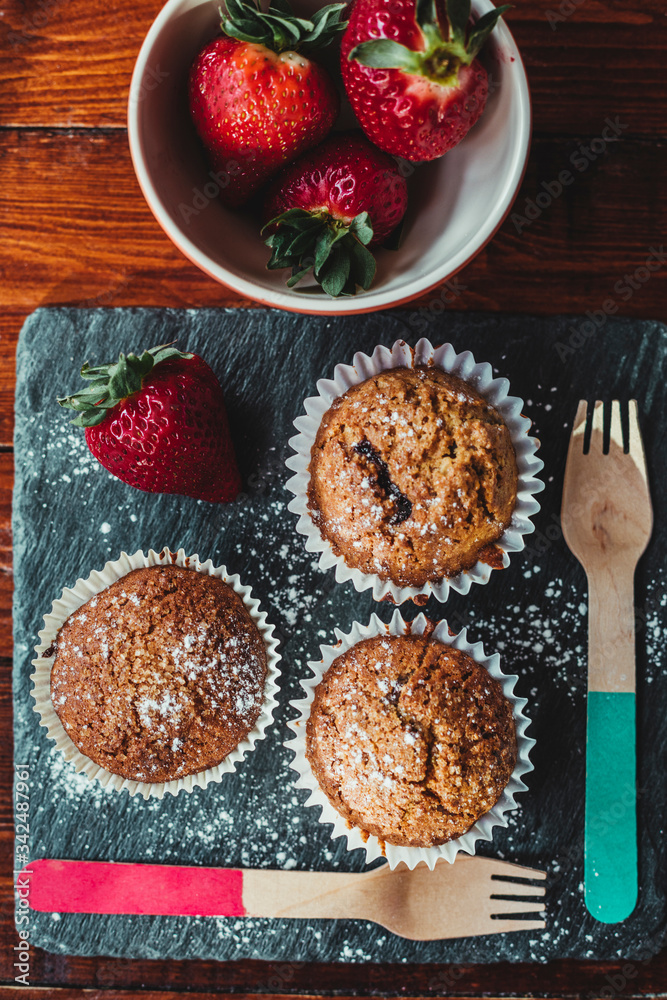 Appetizing Chocolate Muffins made with wholemeal flour and brown sugar with strawberries for a healthy breakfast. Appetizing Chocolate Muffins made with wholemeal flour and brown sugar with strawberries for a healthy breakfast.