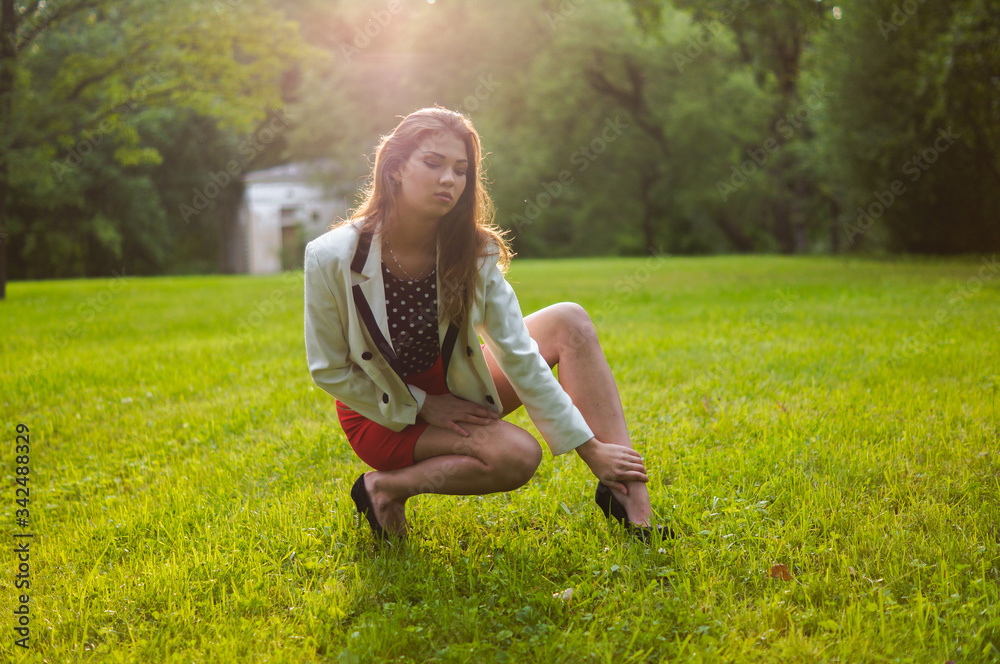 Beautiful and attractive girl is relaxing in the park on a summer day. Dressed and posing like a professional model with glasses and a red skirt Beautiful and attractive girl is relaxing in the park on a summer day. Dressed and posing like a professional model with glasses and a red skirt