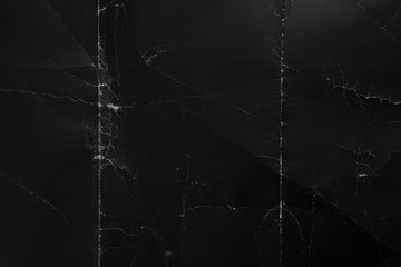 Crumpled black cardboard with wrinkles and wrinkled folds. Old wrapping dusty paper