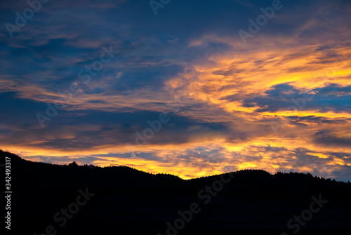 Dramatic clouds in the sky at sunrise in rural Guatemala, silhouette of mountains, forest area.