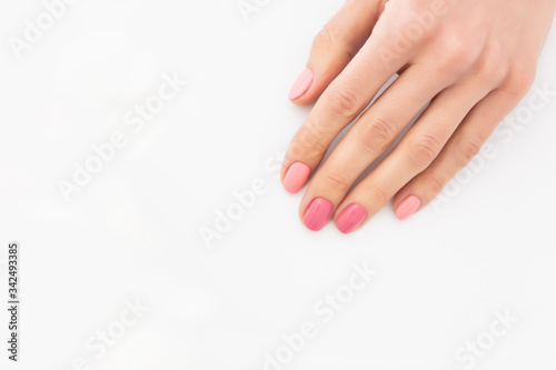 Female hand on a white background close-up. Beautiful manicure on the hand, white background
