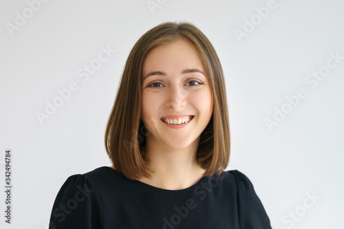 Portrait of a happy cute woman in a black dress on a white background smiling