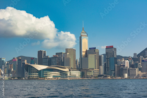 Cityscape of Hong Kong Island by the sea. Modern buildings, advertising, lighting and famous buildings and convention centre. Beautiful day, blue day. 