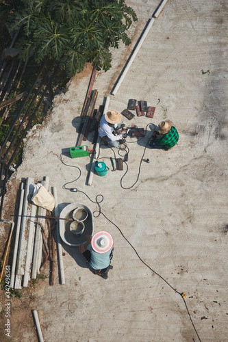 Thai men workers doing construction jobs on the street in the middle day.