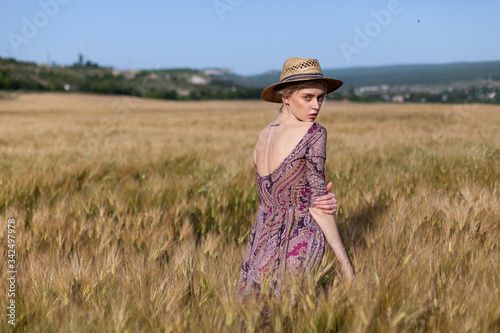Portrait of a beautiful fashionable woman in a field harvesting