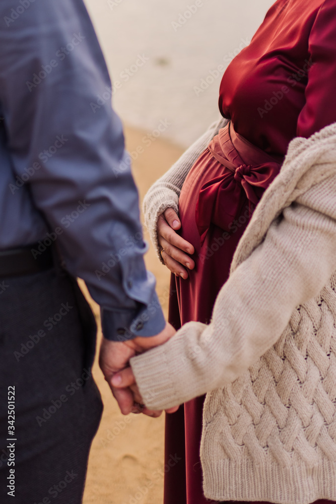 pregnant girl holding her husband's hand pregnant girl holding her husband's hand