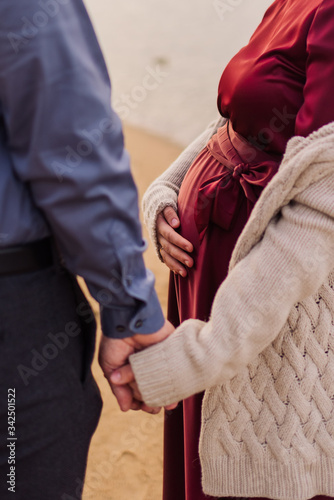 pregnant girl holding her husband's hand