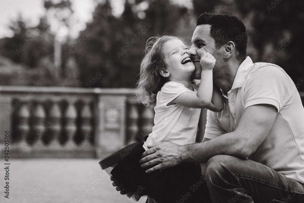 Handsome young father playing with his little daughter in sunny summer park near the castle Handsome young father playing with his little daughter in sunny summer park near the castle