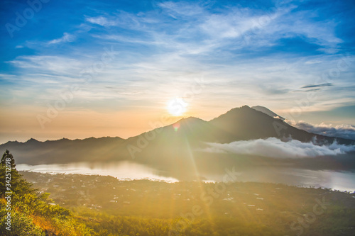 A magnificent landscape view of kintamani volcano from the top of the Mount Batur during the sunrise with fog