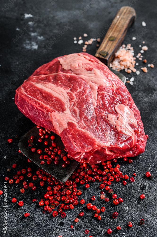 Raw Chuck eye roll steak on meat cleaver. Organic beef. Black background. Top view