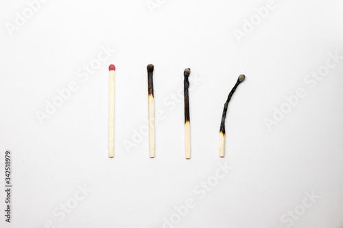 Several matches in different states of combustion on a white background
