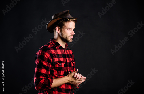 Cowboy life came to be highly romanticized. Masculinity and brutality concept. Adopt cowboy mannerisms as a fashion pose. Man unshaven cowboy black background. Archetypal image of Americans abroad