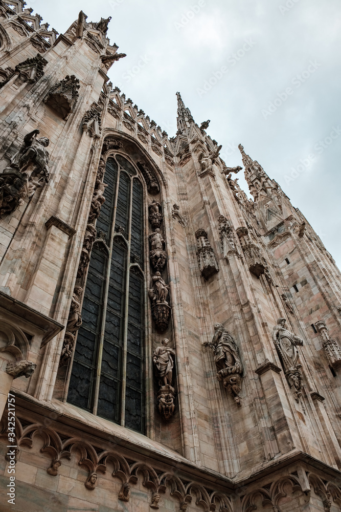 Low angle view of a side with a large window of the Milan Cathedral