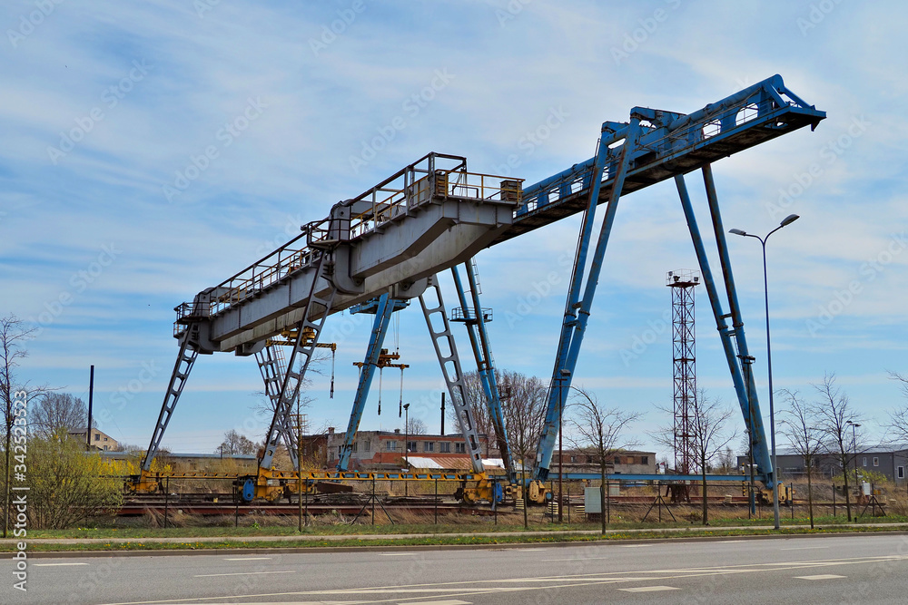 Two large metal gantry cranes. Type of bearing metal structures of gantry crane against the blue