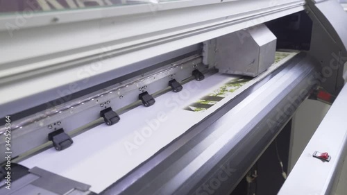 Industrial printing modern digital inkjet printer puts a picture on a cloth canvas
 photo