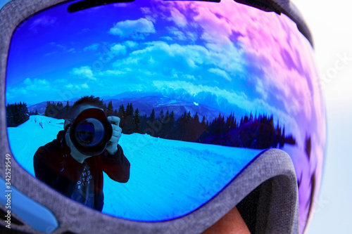 Photographer and camera reflected in goggles
