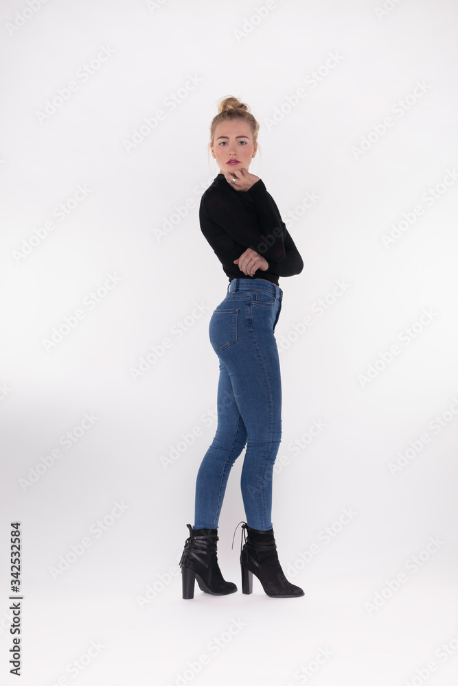Pretty teen girl in skinny jeans standing with arms folded. Stock Photo |  Adobe Stock