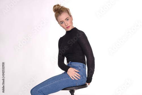 Pretty teen girl in black sweater smiling and giving two thumbs up gesture. 