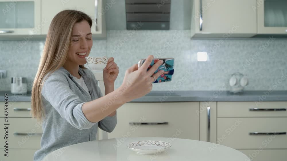 Selfie happy person. Woman surfing social media on smartphone at home. Pretty girl with pink hair takes a selfie and does not notice fire in the kitchen. Selfie happy person. Woman surfing social media on smartphone at home. Pretty girl with pink hair takes a selfie and does not notice fire in the kitchen.