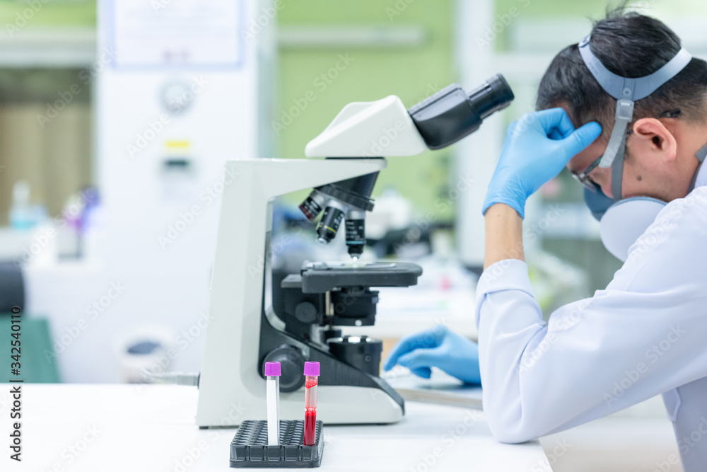 Scientists are studying research on the germs that cause COVID-19, the main cause of illness and are spreading in the world. (focus at tube)