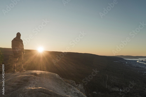 Man standing on a rock and watching sunrise.