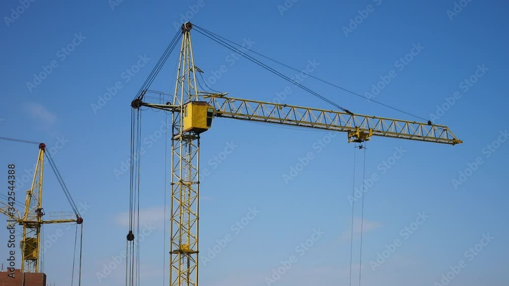 A crane lifts a load at the construction site A crane lifts a load at the construction site