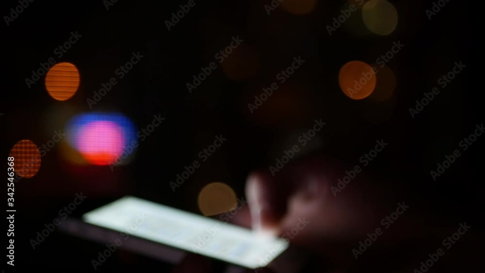 Smartphone using at night - blurred out of focus concept footage