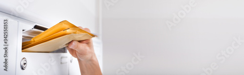 Canvas Print Postman Putting Letters In Mailbox