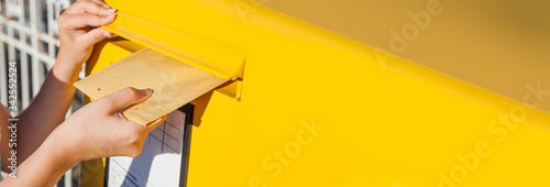 Woman inserting envelope in mailbox photo