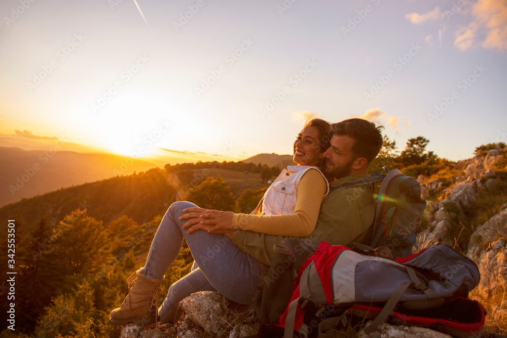Couple Man and Woman sitting on cliff enjoying mountains and clouds landscape Love and Travel happy emotions Lifestyle concept.