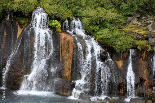 Hraunfossar / Iceland - August 15, 2017: Hraunfossar waterfalls formed by rivulets streaming out of the Hallmundarhraun lava field formed by the eruption of a volcano, Iceland, Europe