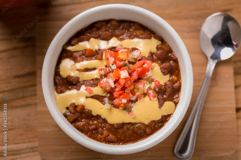 Vegetable Chili with pico de gallo and spoon on the side Vegetable Chili with pico de gallo and spoon on the side