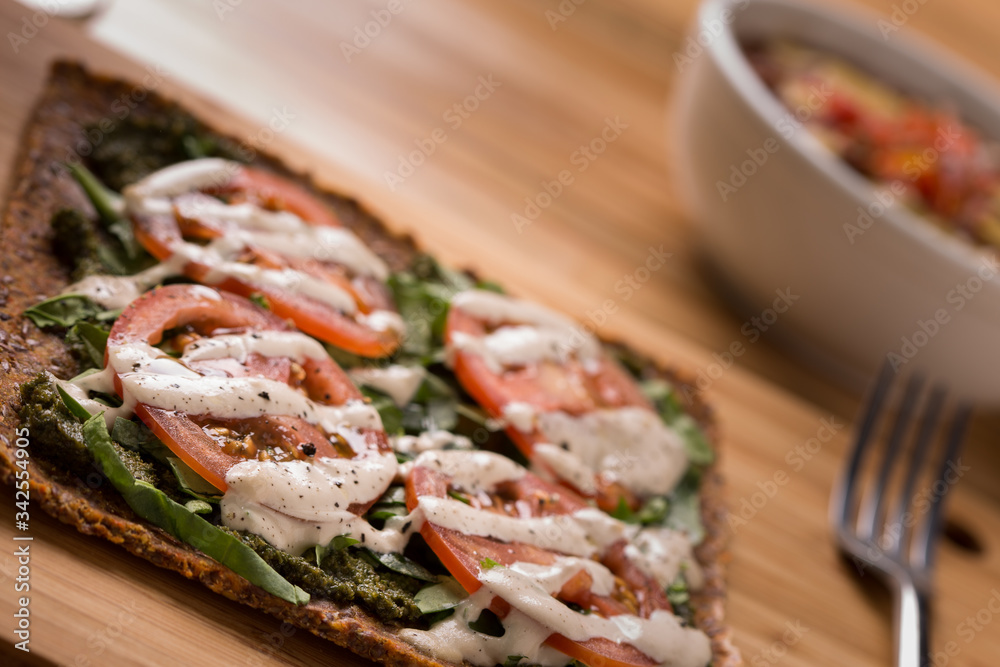 Raw Pizza with gluten free crust, tomatoes, cashew cheese with side dishes