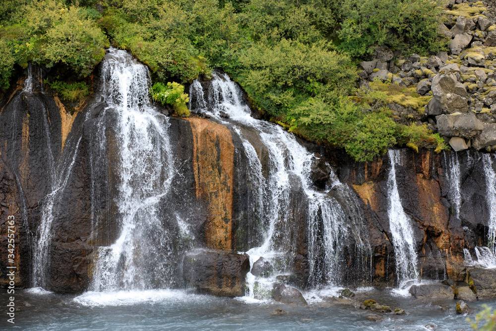 Fototapeta premium Hraunfossar / Iceland - August 15, 2017: Hraunfossar waterfalls formed by rivulets streaming out of the Hallmundarhraun lava field formed by the eruption of a volcano, Iceland, Europe