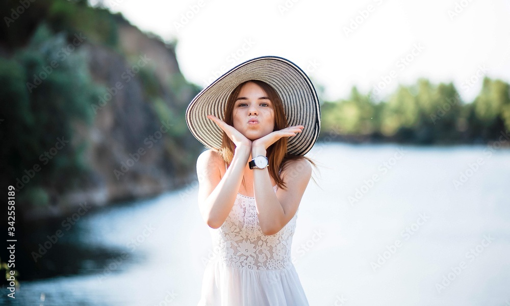 Teenage girl wearing colorful clothes on beach with hat. Portrait of a girl. Summer.
