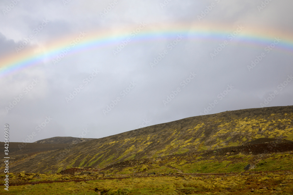 Iceland - August 15, 2017: The spectacullar rainbow arc on a hill near the Ring Road, Iceland, Europe