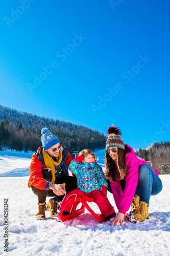 Happy Family In Snow Riding On Sledge.