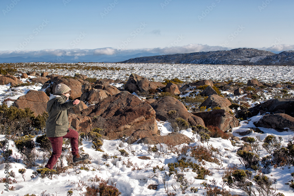 Young boy exploring and playing on a snow covered Mount Wellington