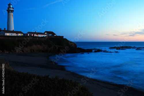 Pigeon Point Lighthouse stands on the rocky coast of California at sunset