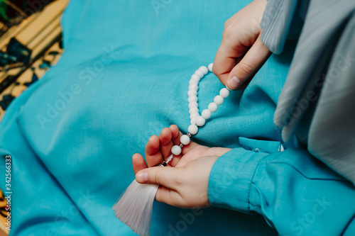 Muslim woman holds muslim rosary in her hands