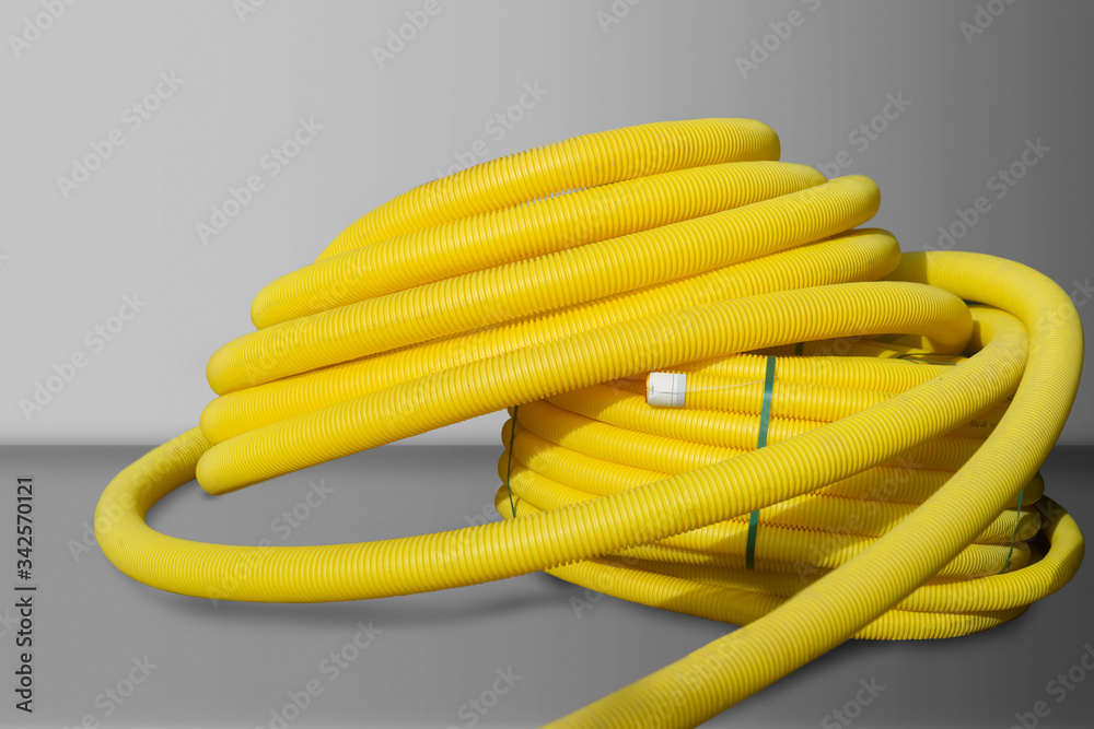 Roll of yellow plastic cable cover on grey background