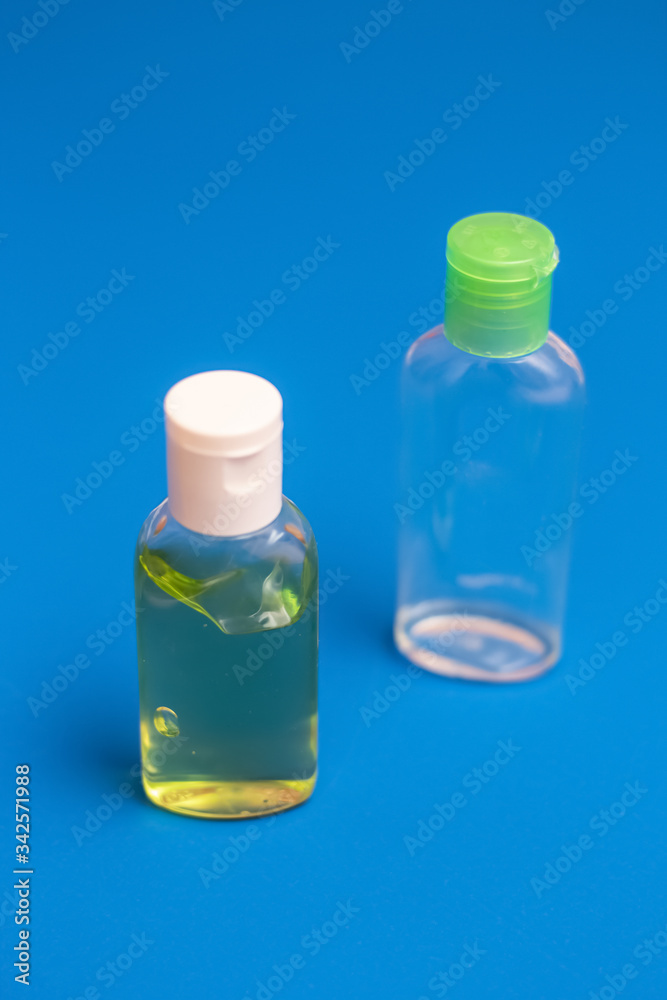 Obraz premium Antiseptic for hands, one full bottle and one empty. On a blue background